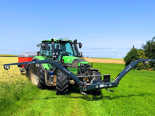 Deutz Traktor steht mit einem Düngerstreuer und dem GreenSeeker in einem Feld.