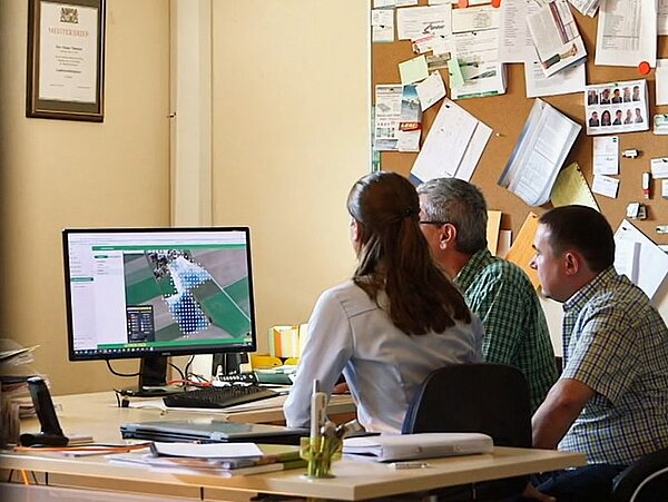 Screenshots eines ARD alpha Beitrags, bei dem zwei Landwirte mit einem NEXT Farming Mitarbeiter vor dem Computer sitzen