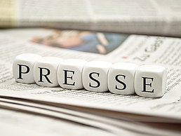 Sechs Würfel liegen auf Zeitung mit jeweils einem Buchstaben des Wortes "Presse".